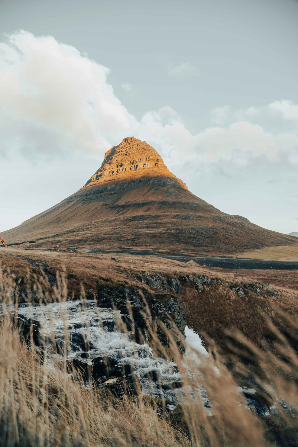 Iconic Kirkjufell Mountain, gracefully framed by a cascading waterfall, creating a mesmerizing natural vista.