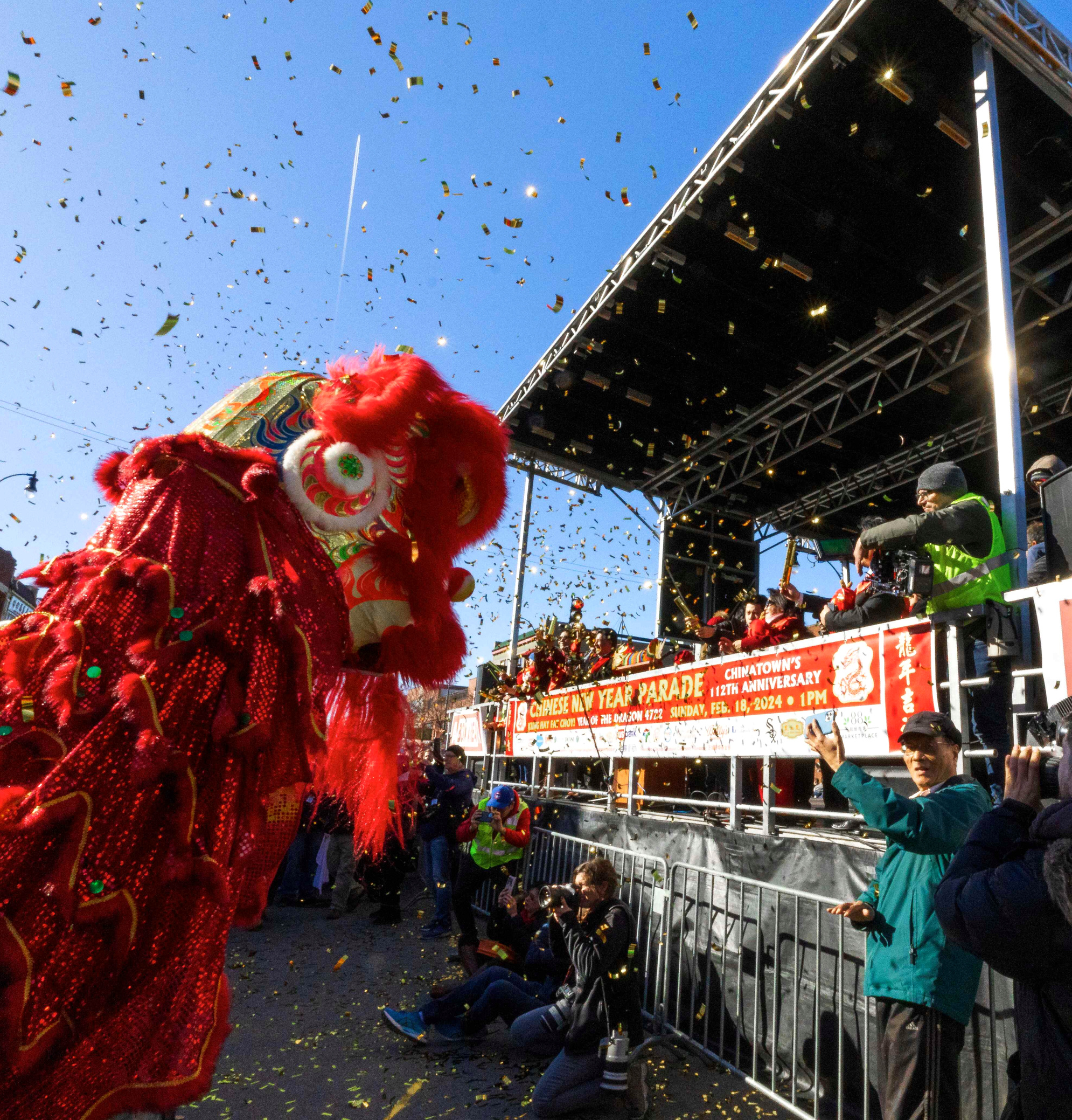 Lion Dance Lion dance performance in front of the main stage at Chicago’s Chinatown Lunar New Year celebration, with gold confetti flying through the air.