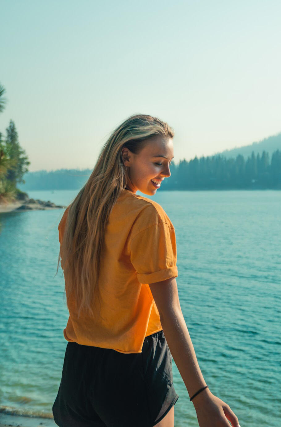 A moment captured in Shaver Lake, California, featuring a cheerful young woman in a yellow shirt