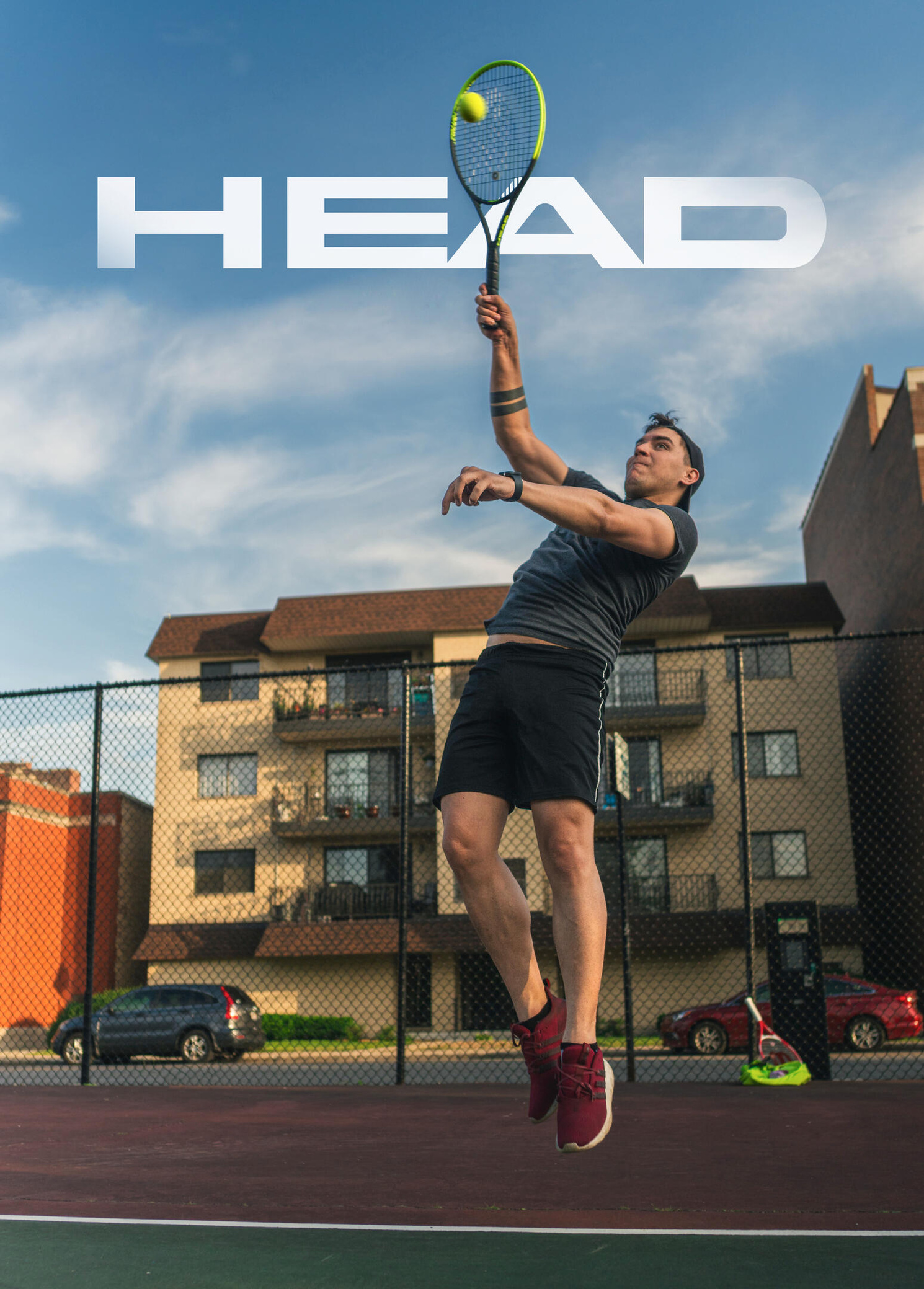 HEAD Tennis Photo of a tennis player hitting a tennis ball at the top of his jump.