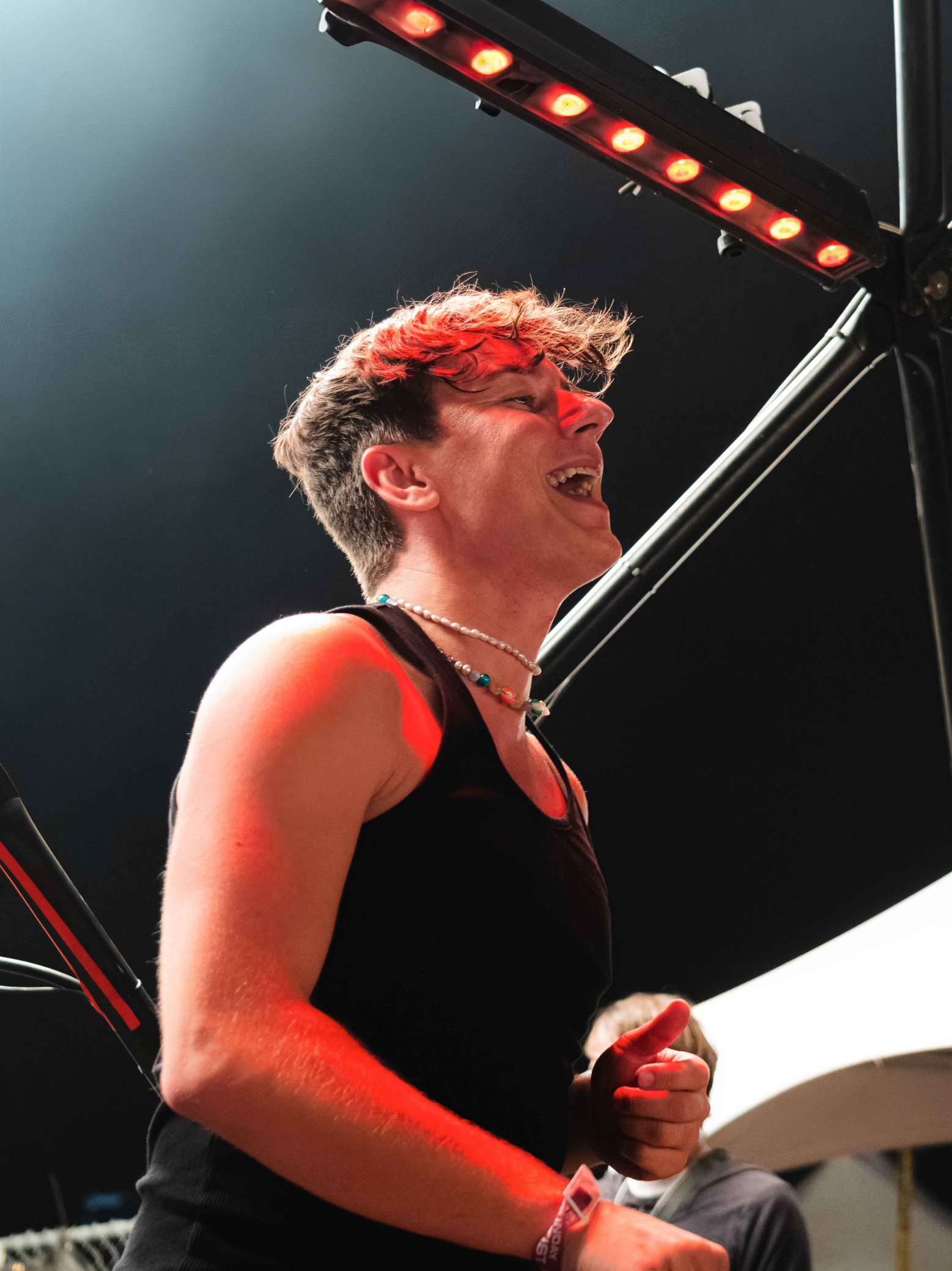 BUNT BUNT performing on stage at North Coast 2024, laughing with red lights glowing behind him.