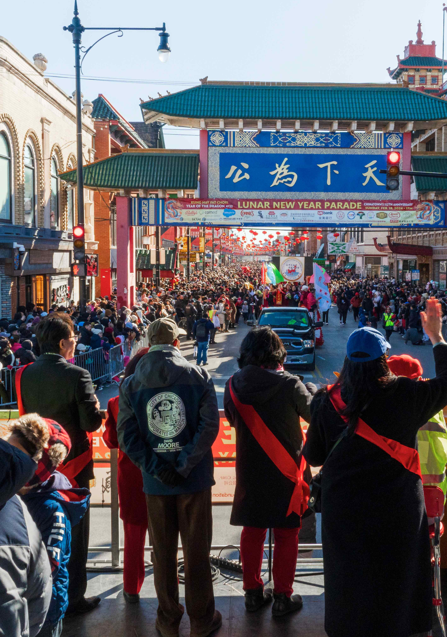 Lunar New Year View from the main stage at Chicago’s Chinatown during the Lunar New Year celebration, showing parade floats passing by as announcements are made.